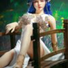 Fantasy elf-like figure with blue hair and ornate silver headpiece sitting on a wooden railing in a garden setting.