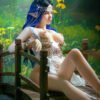 Blue-haired elf woman with an ornate headpiece sits on a wooden bridge in a green forest setting.