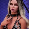 Close-up of a woman with blonde hair wearing black leather harness and silver chains, posing against a blue backdrop with grid patterns.