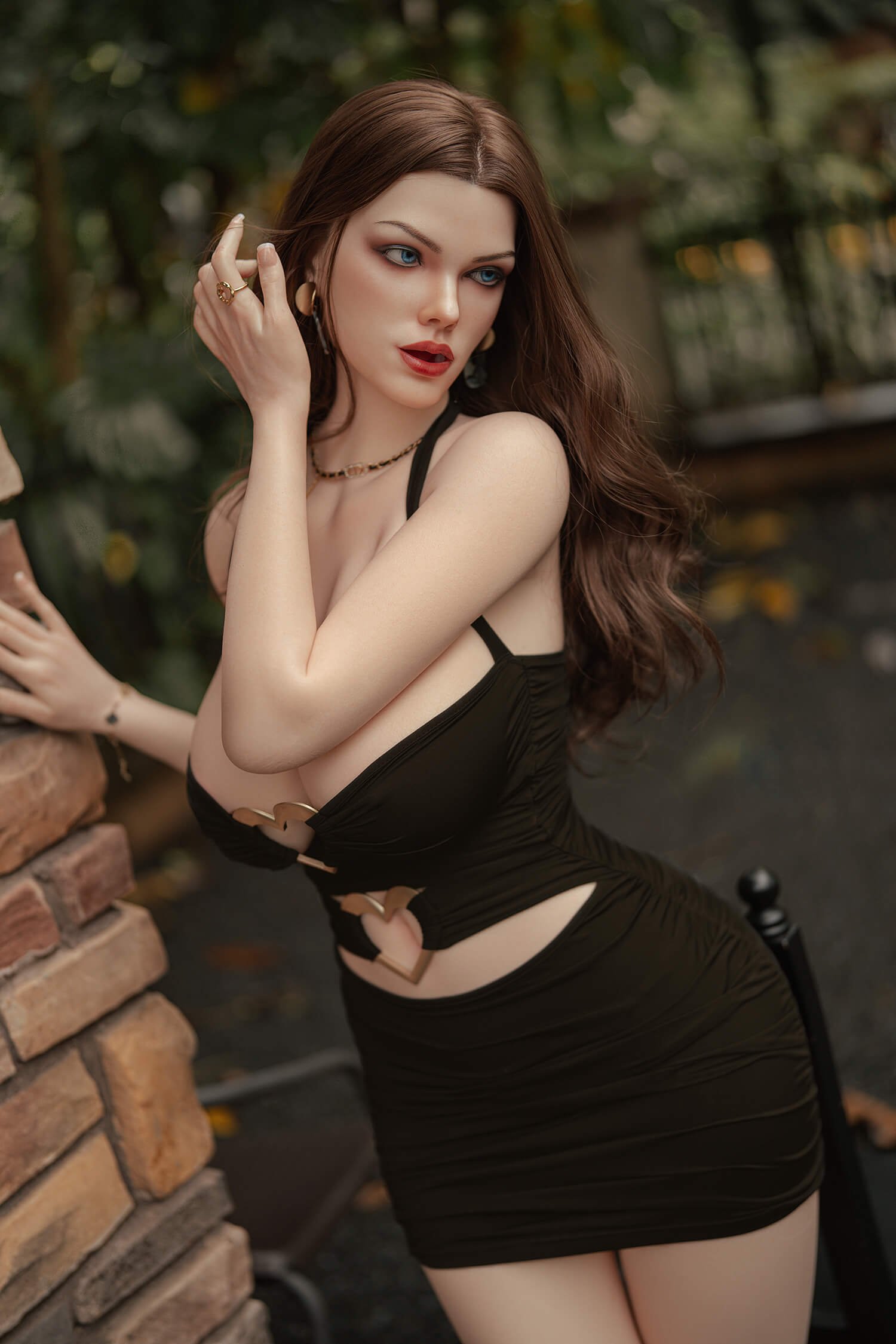 Woman in a black cutout dress posing outdoors near a brick stack, looking to the side.
