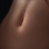Close-up of the back of a neck with smooth skin and a small mole visible near the center edge of the image.