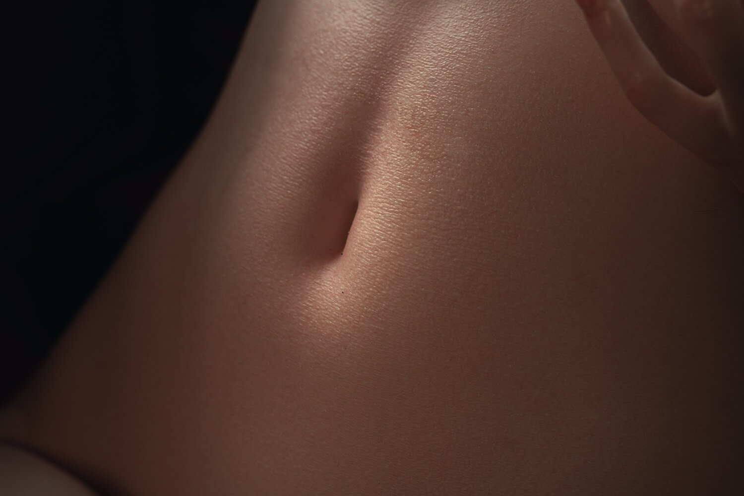 Close-up of the back of a neck with smooth skin and a small mole visible near the center edge of the image.