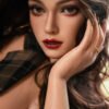 Close-up portrait of a woman with brown eyes, smoky red makeup, and glossy red lips, touching her hair near her face.
