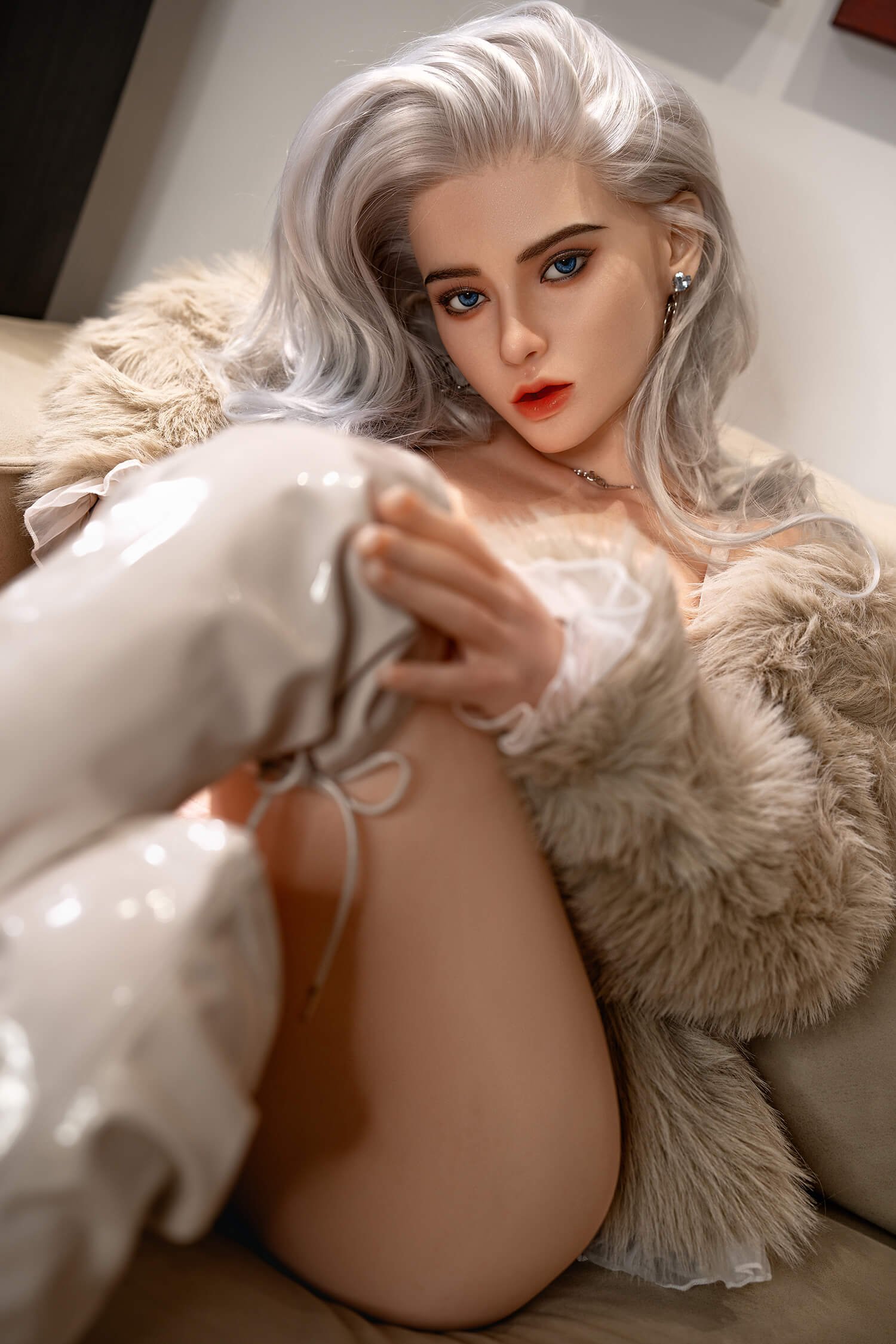 Close-up portrait of a woman with platinum silver hair and blue eyes, wearing a fur coat and red lips, looking at the camera.
