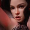 Close-up portrait of a woman with glossy lips and defined makeup, hands framing her face under red lighting.