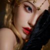 Close-up of a woman wearing a gold chain headpiece, blue eye makeup, and red lips, with a black velvet garment partially covering her face.