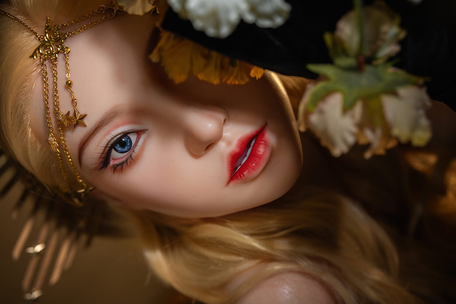 Close-up portrait of a woman with blonde hair, wearing a gold decorative headpiece, and bold red lips amid white flowers