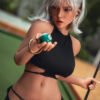 Woman with platinum blonde hair in a black bikini extends her arm toward the camera, holding a small green ball outdoors.